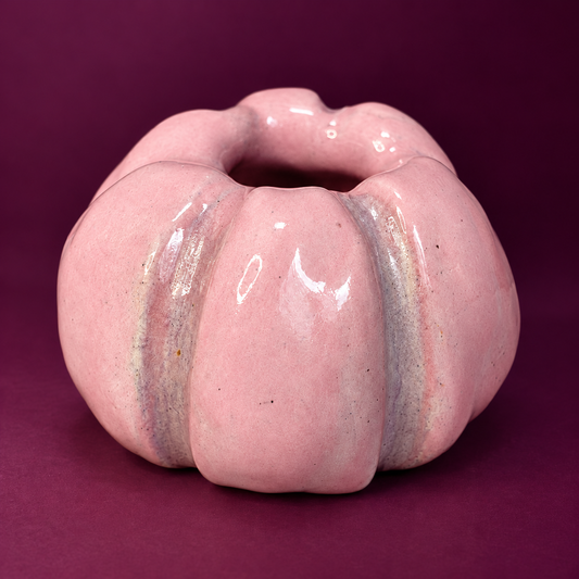 Close view of the glossy light pink ceramic pumpkin taper holder with mauve groove details.
